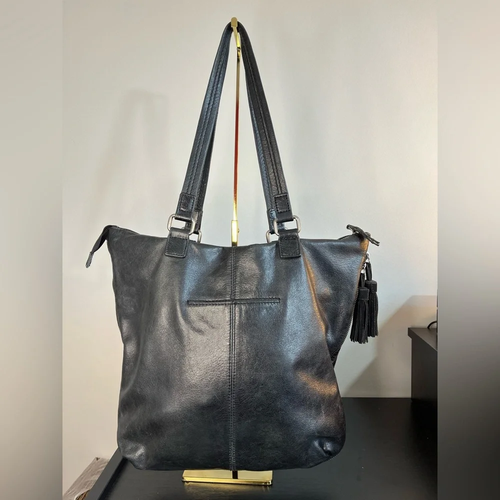 The Sak Expandable Black Leather Suede Shoulder Tote Bag with Suede Tassels